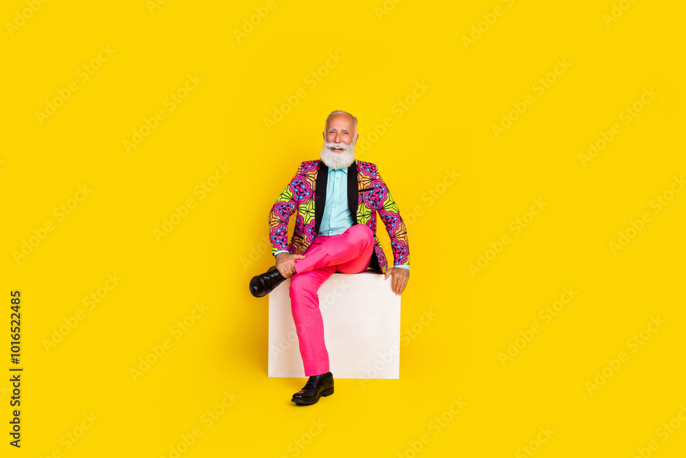 Full size photo of handsome pensioner mister sit white cube dressed colorful pink classy garment isolated on yellow color background