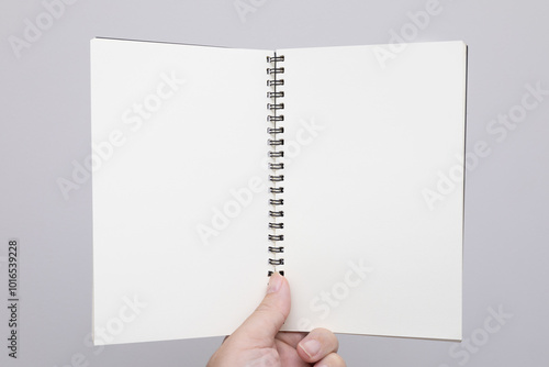 Hand holding an empty notebook or book. Mockup book. Blank notebook, blank book. free space on book for adding texts.