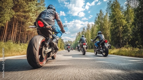 A group of motorbikes on the forest road riding. having fun driving the empty road on a motorcycle tour journey. In summer against a blue sky. Concept of motorsport, speed. Back bottom view