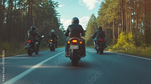 A group of motorbikes on the forest road riding. having fun driving the empty road on a motorcycle tour journey. In summer against a blue sky. Concept of motorsport, speed. Back view
