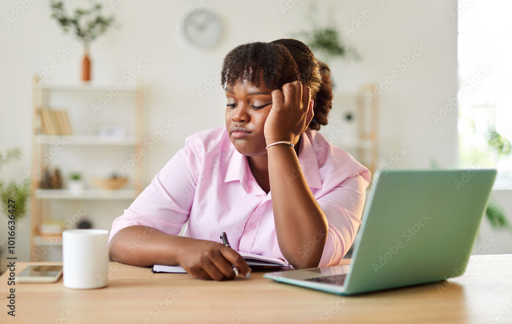 Unhappy african american girl sitting at home with laptop and bored. Young woman tired of internet. Concept procrastination, small business, problem solving, burnout at work, remote job Unhappy african american girl sitting at home with laptop and bored. Young woman tired of internet. Concept procrastination, small business, problem solving, burnout at work, remote job