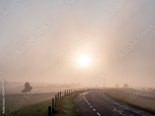 river dike of lek in province of utrecht in holland on foggy morning near wijk bij duurstede photo