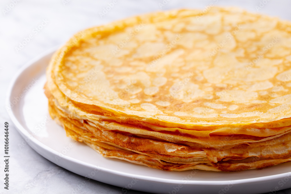 Crepes, thin pancakes with honey on a white plate. Marble background. Close up. Crepes, thin pancakes with honey on a white plate. Marble background. Close up.