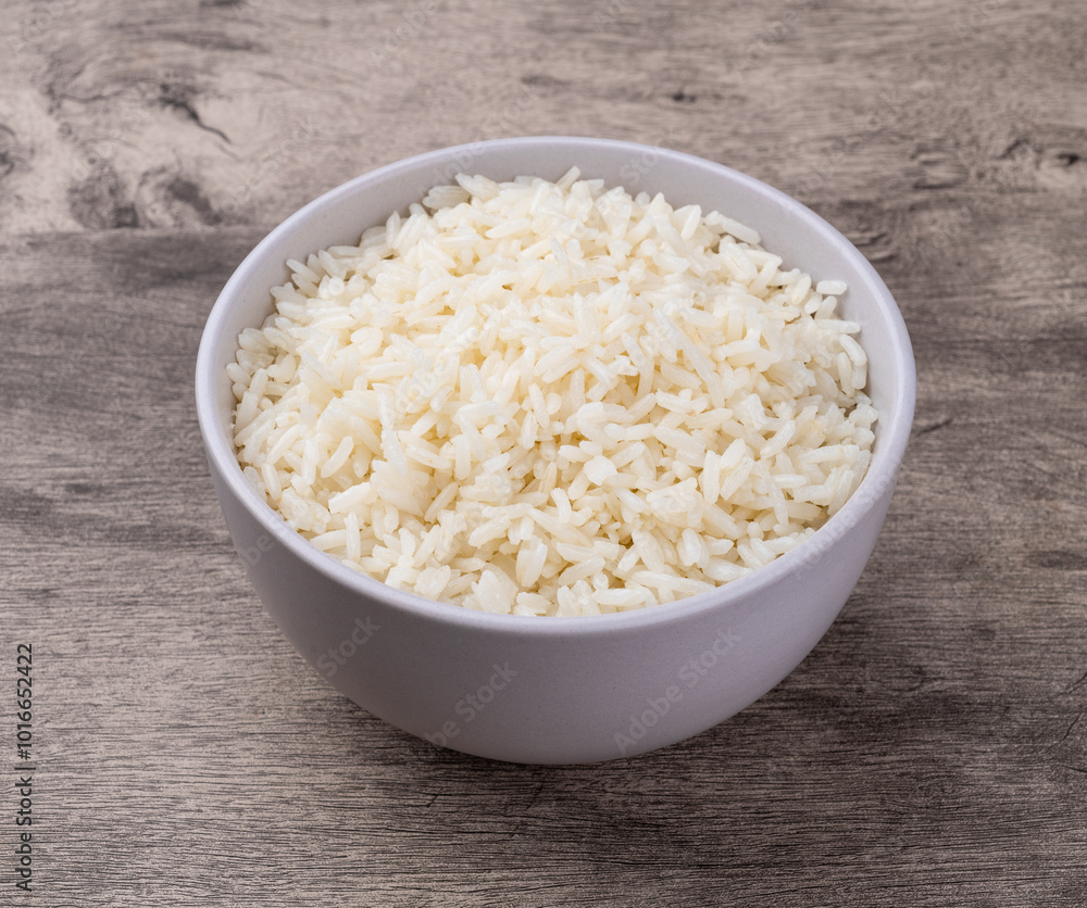 Cooked white rice in a bowl over wooden table Cooked white rice in a bowl over wooden table