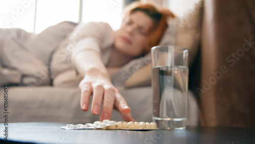 Glass of water and cure drugs pills painkiller on table bad feeling sick ill unhealthy unwell girl woman suffering from headache ailing girl hangover in bed morning migraine painful head fever pain