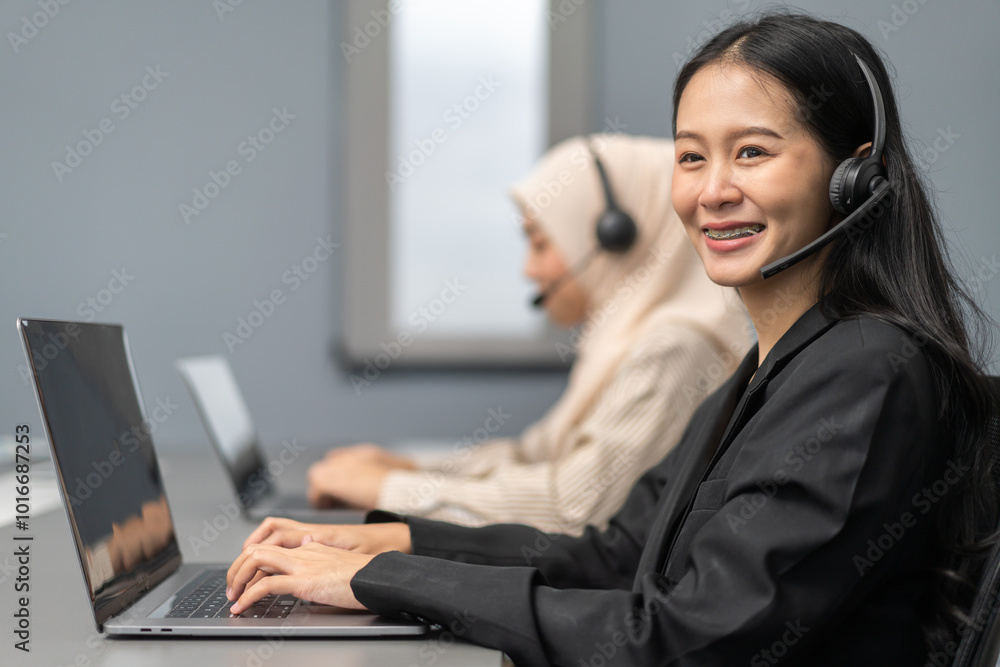 Two female customer service representatives wearing headsets working on laptops in office call center support calls and assisting clients with professional communication skills, teamwork concept Two female customer service representatives wearing headsets working on laptops in office call center support calls and assisting clients with professional communication skills, teamwork concept