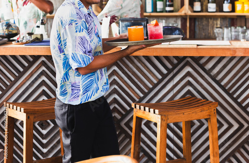 Waiter serving cocktail dink on a tray. photo