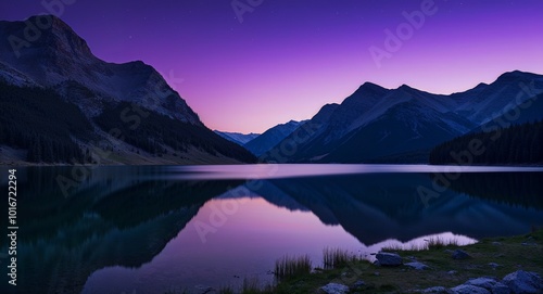 Purple twilight over still lake with mountains