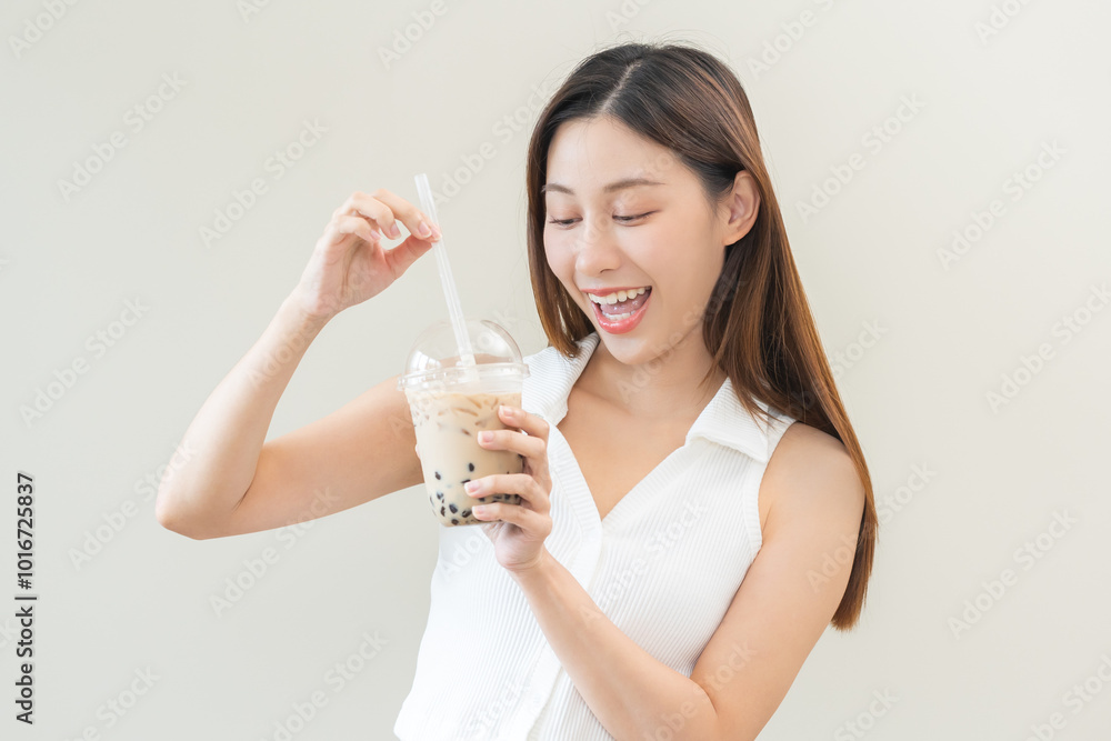 Beverage and food concept, Happy asian young woman hand holding plastic cup, glass of drink bubble, pearl milk tea with straw, cute girl drinking ice cold tea with tapioca boba ball popular in Taiwan. Beverage and food concept, Happy asian young woman hand holding plastic cup, glass of drink bubble, pearl milk tea with straw, cute girl drinking ice cold tea with tapioca boba ball popular in Taiwan.