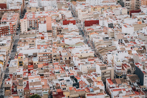 Aerial view of urban housing area with a mix of streets, rooftops, and old residential buildings, portraying city life in a crowded environment.