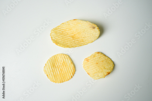 Crispy Yellow Wavy Snack on White Background – Minimalist Food Photography