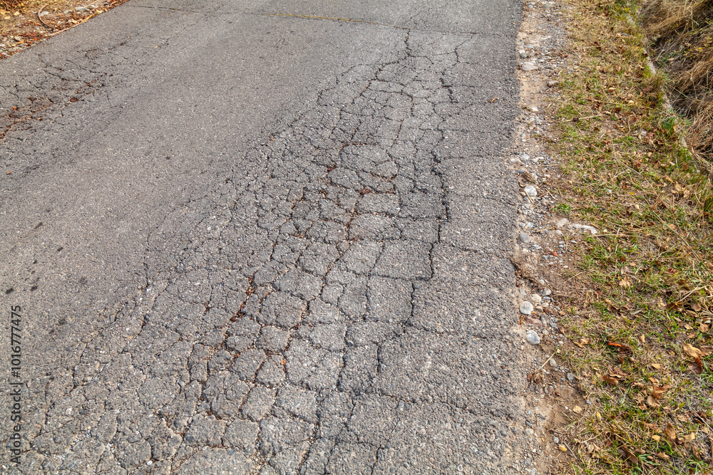 Naklejka premium road from broken and destroyed asphalt unsuitable for driving