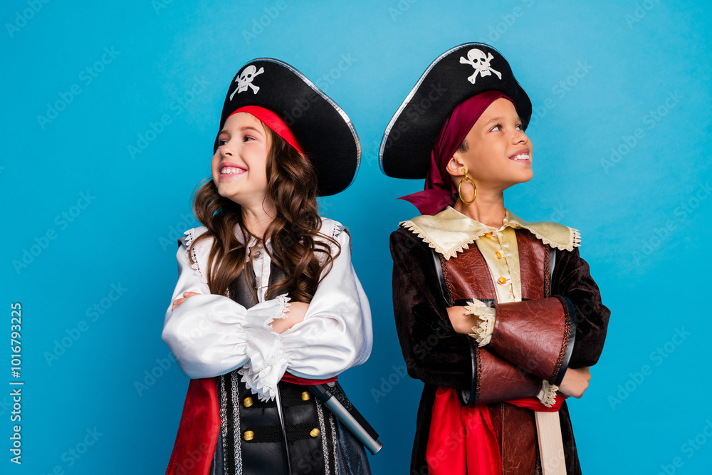 Portrait of two little kids halloween pirate costume folded hands look empty space isolated on blue color background Portrait of two little kids halloween pirate costume folded hands look empty space isolated on blue color background