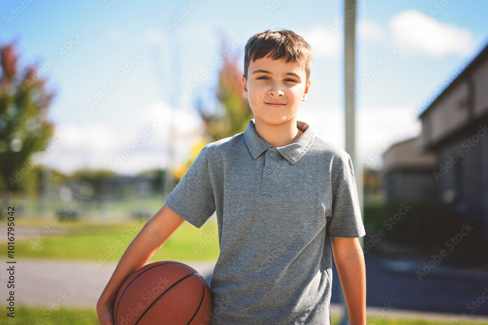 sporty boy wear grey sports clothes play basketball game on playground court