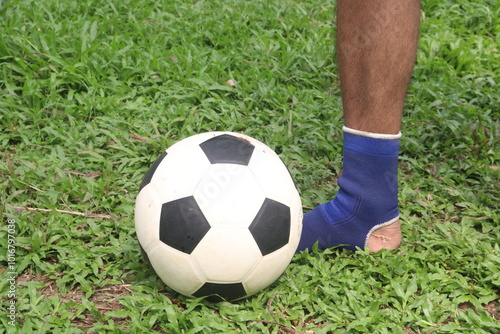 Soccer ball with leg on grass