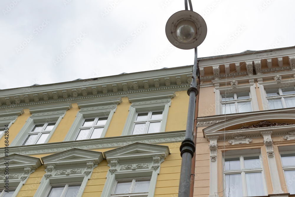 There is a tall building standing with a street light positioned right in front of it, illuminating the surrounding area at night There is a tall building standing with a street light positioned right in front of it, illuminating the surrounding area at night