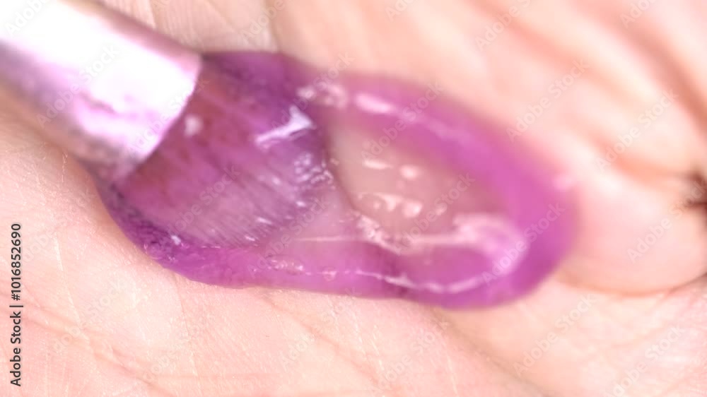 Salt scrub swatch on skin, macro. Sugar purple body scrub gel is smeared with a brush on hand skin Salt scrub swatch on skin, macro. Sugar purple body scrub gel is smeared with a brush on hand skin