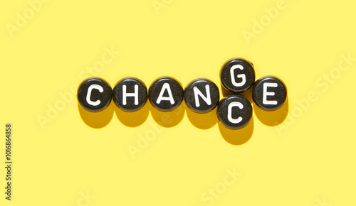 Inspirational concept of change word with letter tiles on vibrant yellow background for transformation and adaptation themes. photo