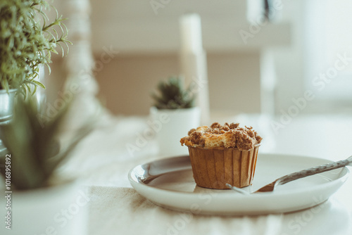 Close-up of a homemade crumble Cupcake on a table with houseplants photo