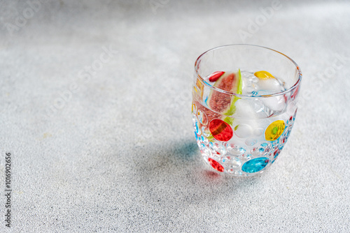 Close-up of a glass of ice water with a slice of fresh fig