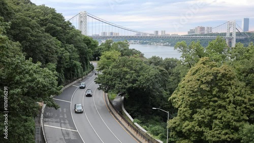 cars driving on the henry hudson parkway (west side of manhattan river) with george washington bridge gwb in the background at sunset 