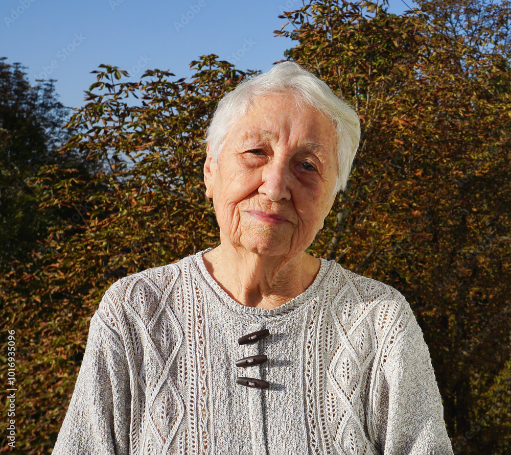 Portrait of sad senior woman posing in autumn park