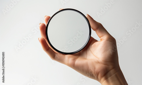 Pocket mirror. Small cosmetic mirror in hand close-up.