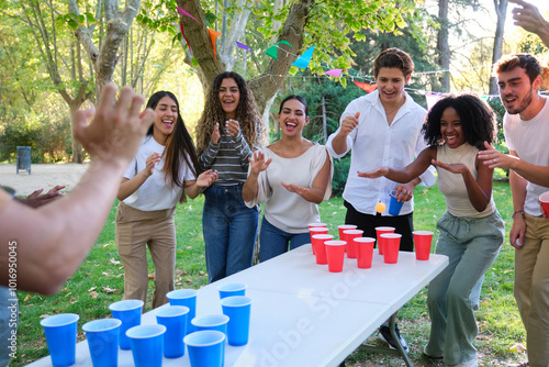 Obraz na płótnie Cheerful young people playing beer pong in park on sunny day w salonie
