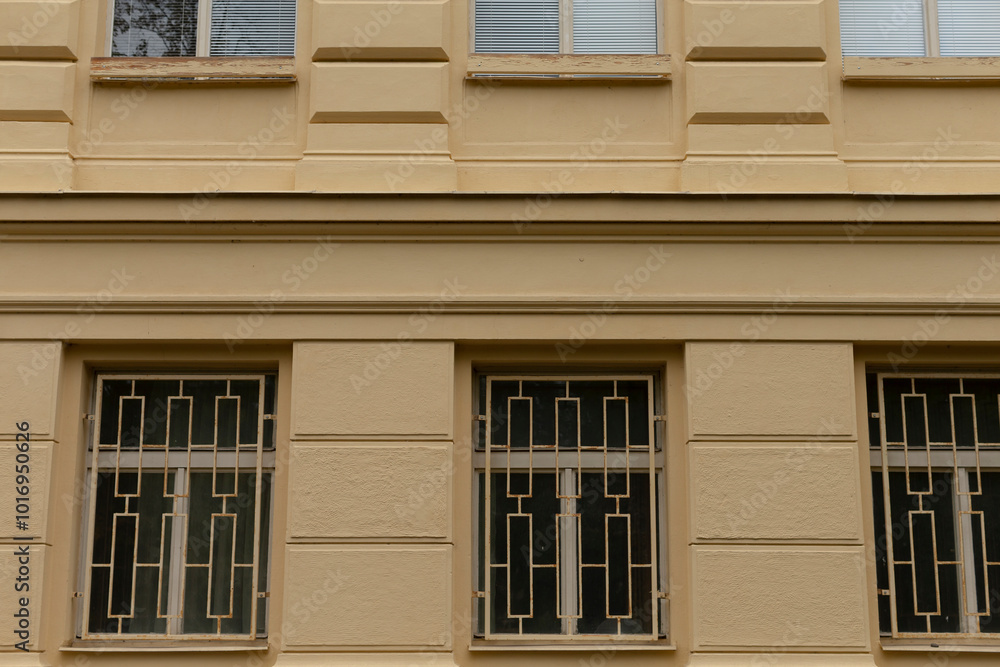 An architectural structure that features a significant number of windows, all of which are secured with bars for added protection An architectural structure that features a significant number of windows, all of which are secured with bars for added protection