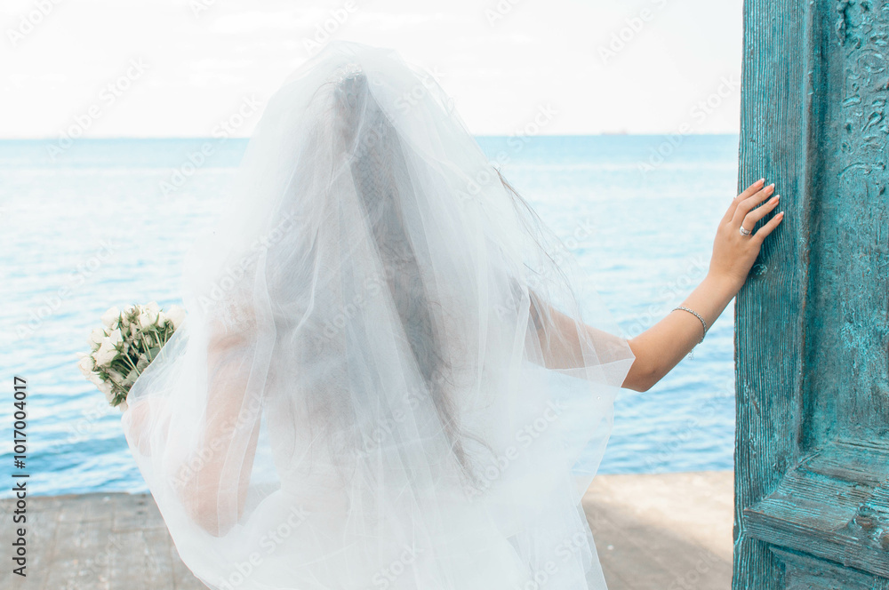 Bride on the coast of the sea. On the bride is a long wedding dress with lace and an open back. Bride on the coast of the sea. On the bride is a long wedding dress with lace and an open back.