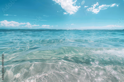 The ocean is calm and clear, with a bright blue sky above