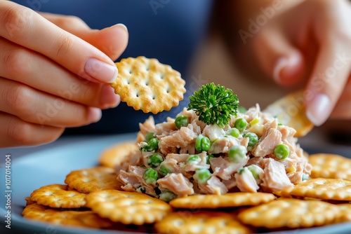 Realistic scene of a person eating a tuna salad with whole grain crackers, showcasing a light yet energizing meal full of protein and healthy fats photo