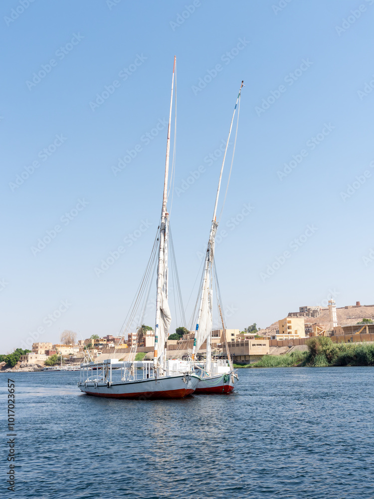 Traditional Egyptian felucca boat sailing down the great Nile River in Egypt.