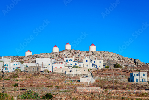 The skyline of Chora of Amorgos, located in the center of the island, overlooking the Aegean Sea. Whitewashed houses and windmills on top of the mountain. Amorgos Island, Cyclades, Greece.