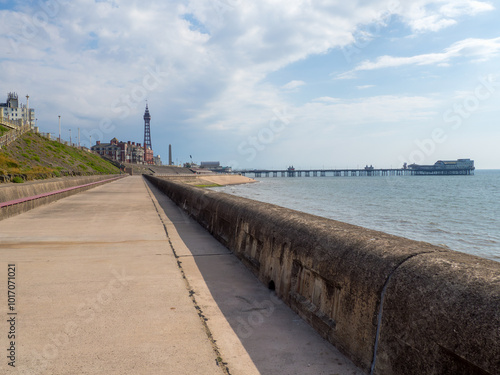 the seafront promenade in north Blackpool with the tower and town buildings in the distance and the north pier at high tide photo