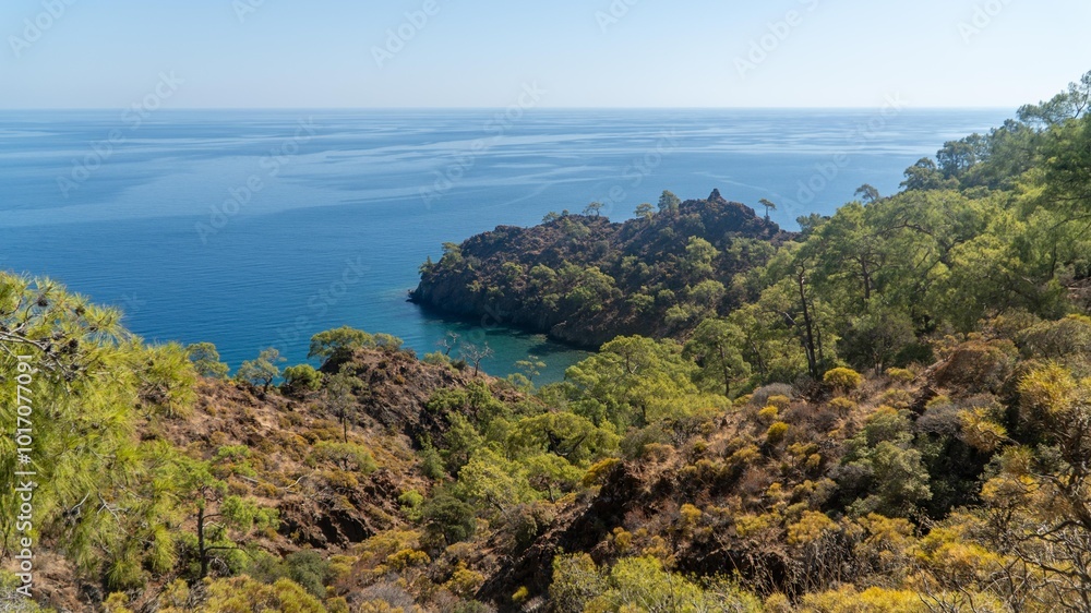 The stunning Turkish Mediterranean coastline as seen from the Lycian Way in Antalya features a blue sea, lush green forests, and rugged rocky shores, attracting tourists every summer. The stunning Turkish Mediterranean coastline as seen from the Lycian Way in Antalya features a blue sea, lush green forests, and rugged rocky shores, attracting tourists every summer.