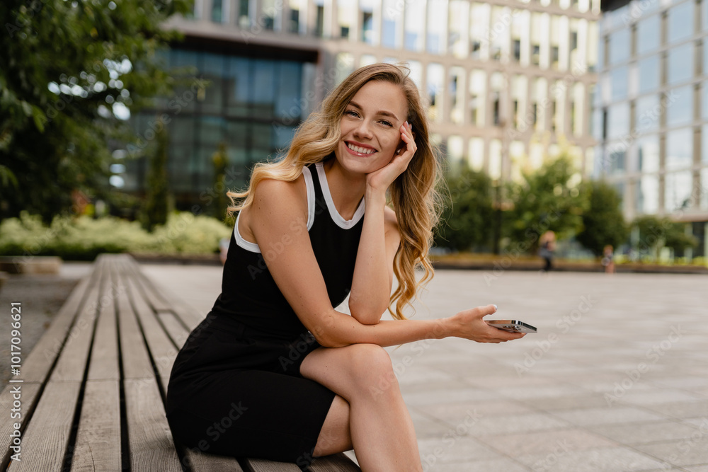 young pretty blond woman sitting outside in street doing business
