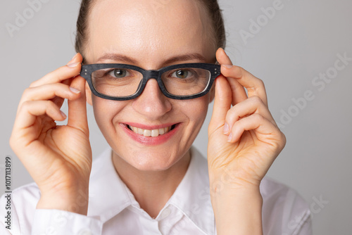 A woman puts on glasses for good vision and smiles because she can see better, good vision photo