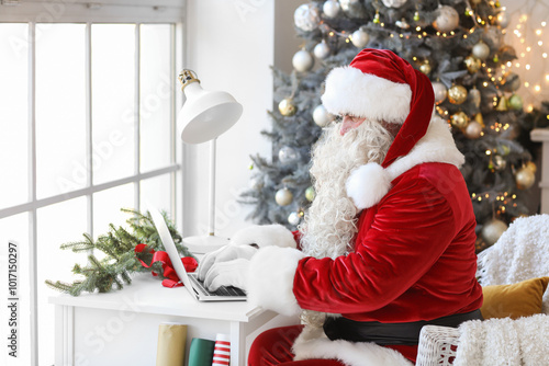 Santa Claus using laptop at...