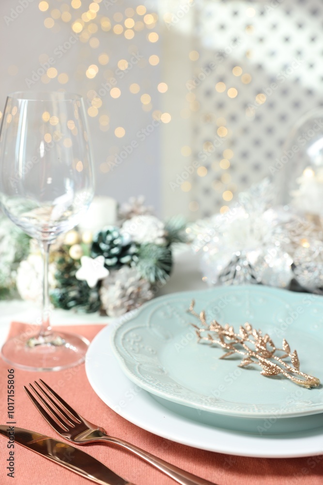 Christmas place setting with plates, cutlery and festive decor on table, closeup Christmas place setting with plates, cutlery and festive decor on table, closeup