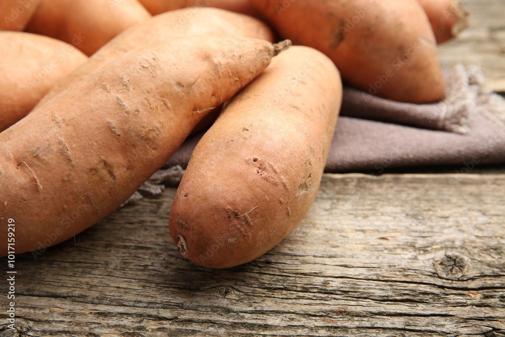 Fresh raw sweet potatoes on wooden table, closeup Fresh raw sweet potatoes on wooden table, closeup