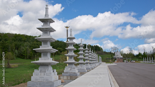 Peterborough, Ontario, Canada / 05-18-2024: The entrance of a Chines Buddhist temple with the stone statue of Happy Buddha in background.