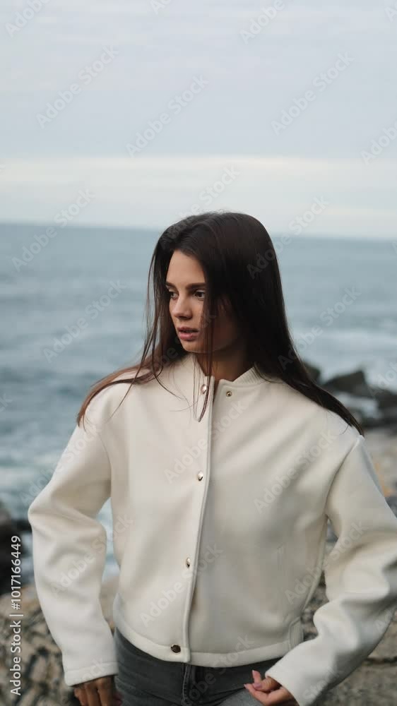 Beauty, fashion portrait of woman, model on the ocean shore in the rocks, soft comfortable clothes, campaign, posing, style, freedom, care, white jacket, twilight, portrait, vertical, face, glamor Beauty, fashion portrait of woman, model on the ocean shore in the rocks, soft comfortable clothes, campaign, posing, style, freedom, care, white jacket, twilight, portrait, vertical, face, glamor