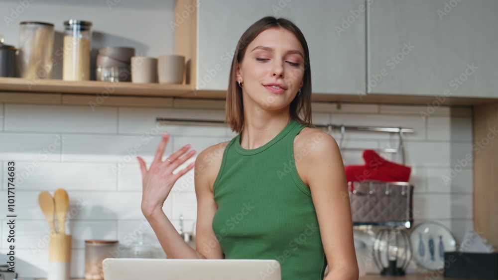 Domestic girl video calling by laptop in home kitchen closeup. Woman talking Domestic girl video calling by laptop in home kitchen closeup. Woman talking