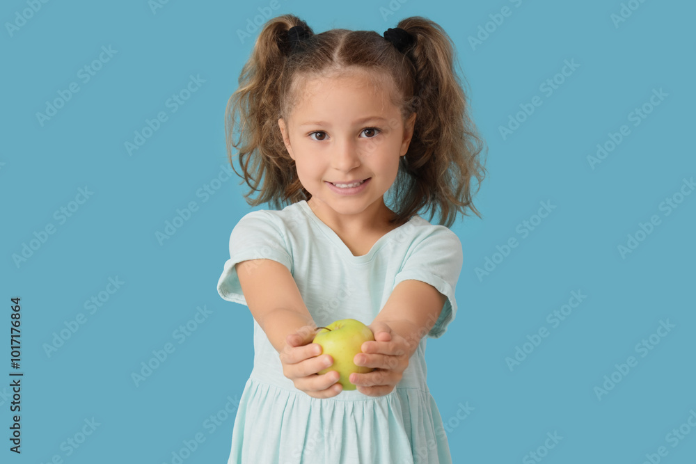 Cute little girl with apple on blue background Cute little girl with apple on blue background