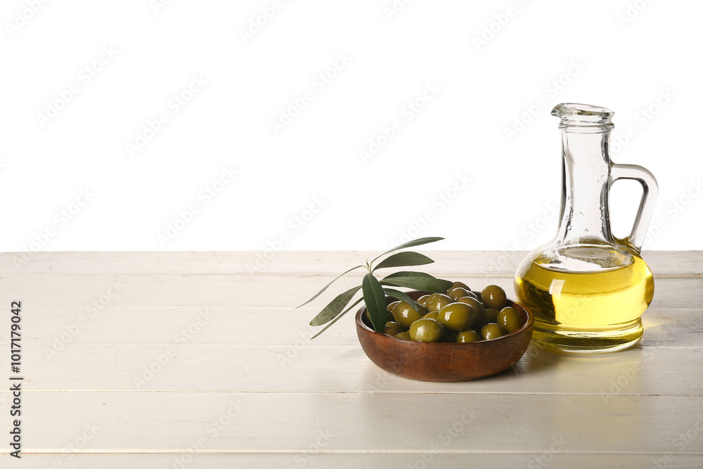 Decanter of fresh olive oil on wooden table against white background Decanter of fresh olive oil on wooden table against white background