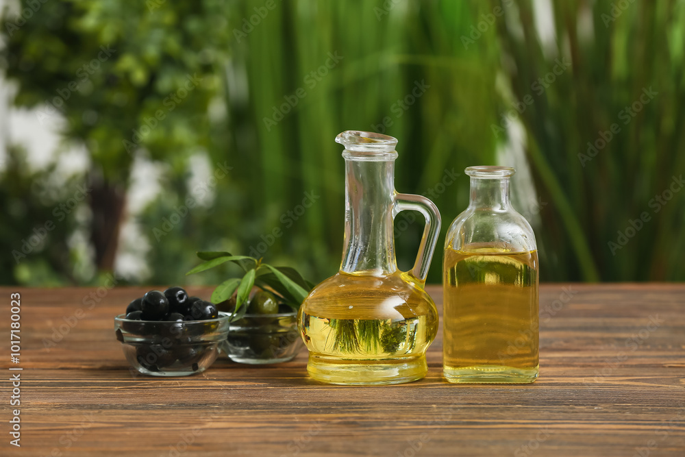 Olives with oil on wooden table against blurred background Olives with oil on wooden table against blurred background