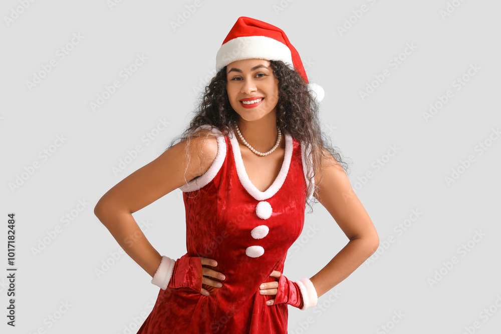 Sexy young African-American woman in Santa hat on grey background Sexy young African-American woman in Santa hat on grey background