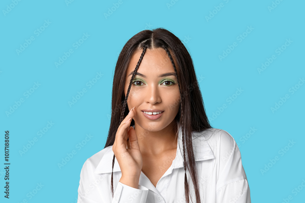 Happy young Asian woman with stylish mint makeup on blue background Happy young Asian woman with stylish mint makeup on blue background
