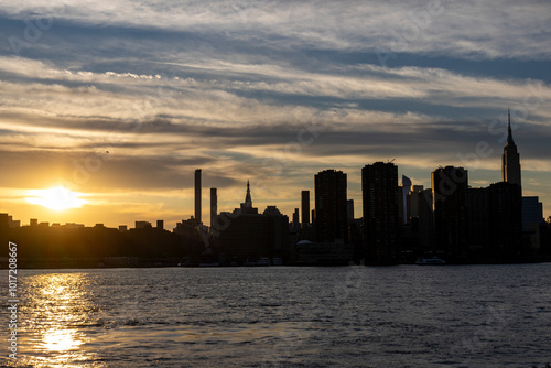 Golden hour view of New York City skyline with silhouettes of skyscrapers in Manhattan photo